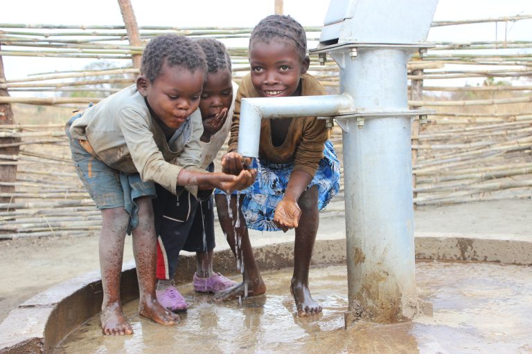 Kids drinking from water well