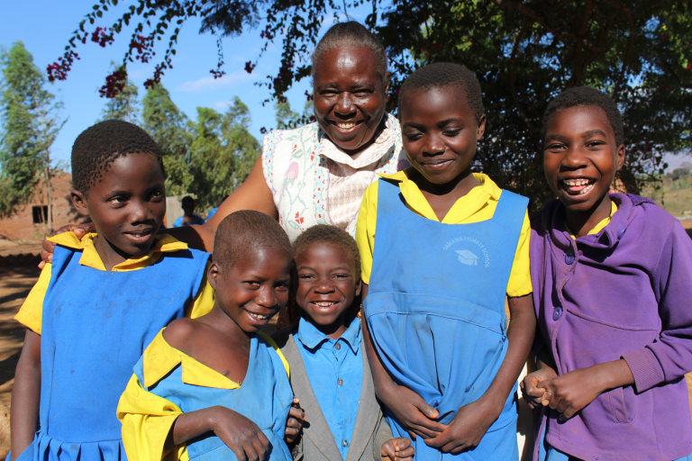 A group of people stand together, smiling