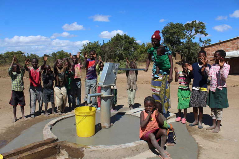 A community gathers around a new water well