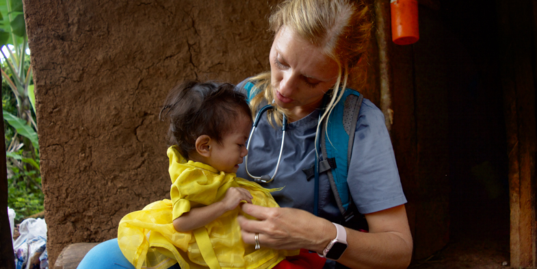 A woman provides medical care to a baby