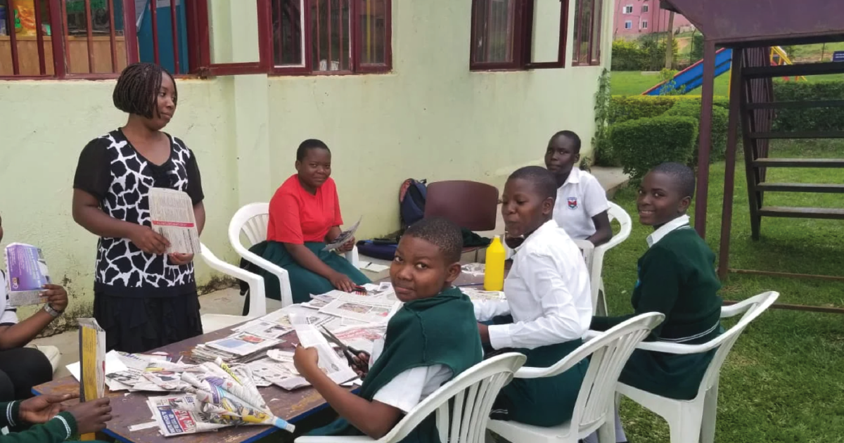 Orphaned children sit in chairs outside