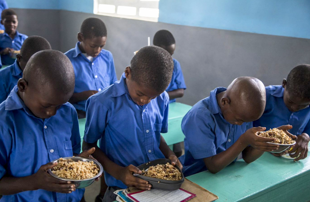 Students praying before taking lunch at school