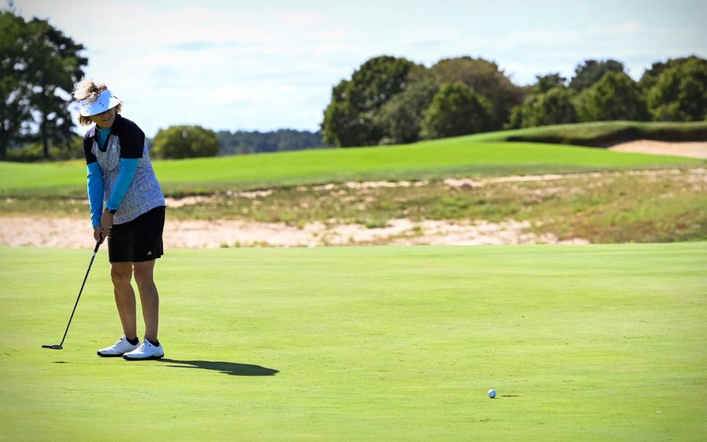 A woman golfer putts