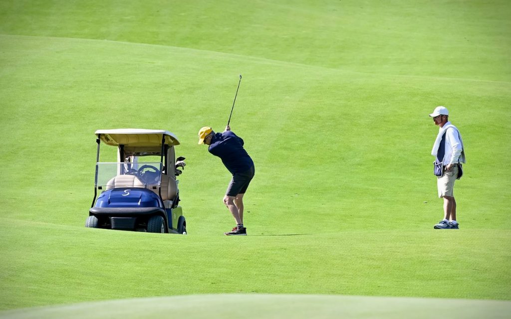 A golfer takes a swing at a ball