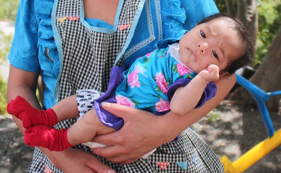 Baby Vilma recovered and resting in an adult's arms