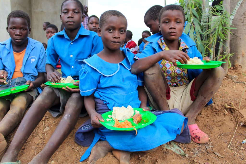 Group of Malawian children receiving lunch