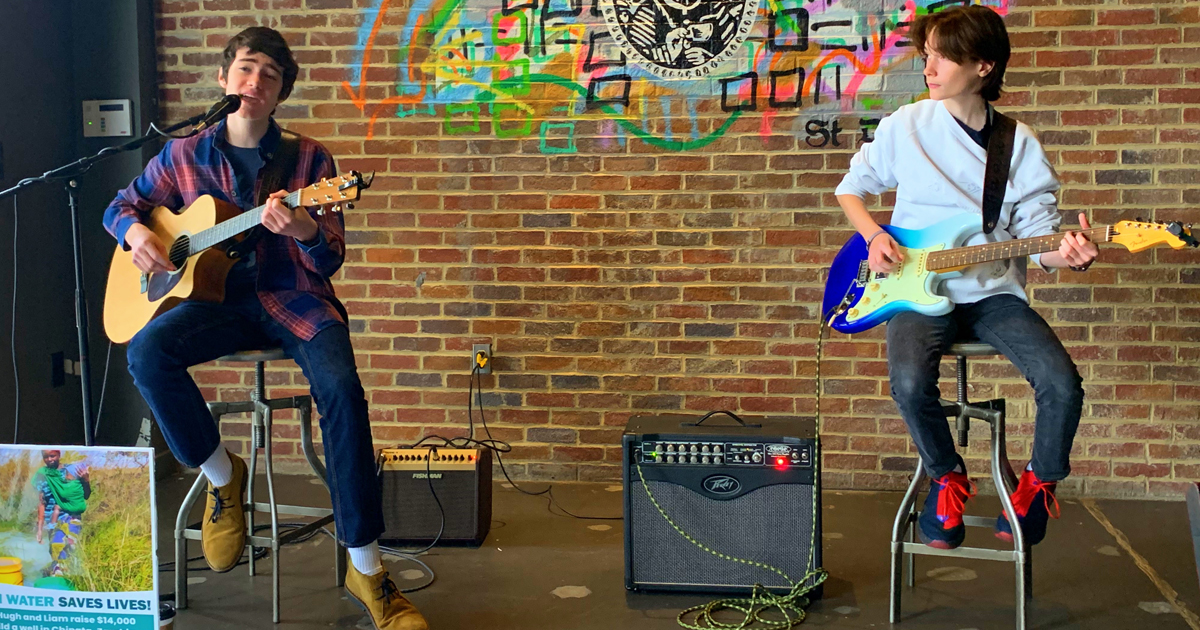 Hugh and Liam playing their music to raise funds to build a well in Zambia