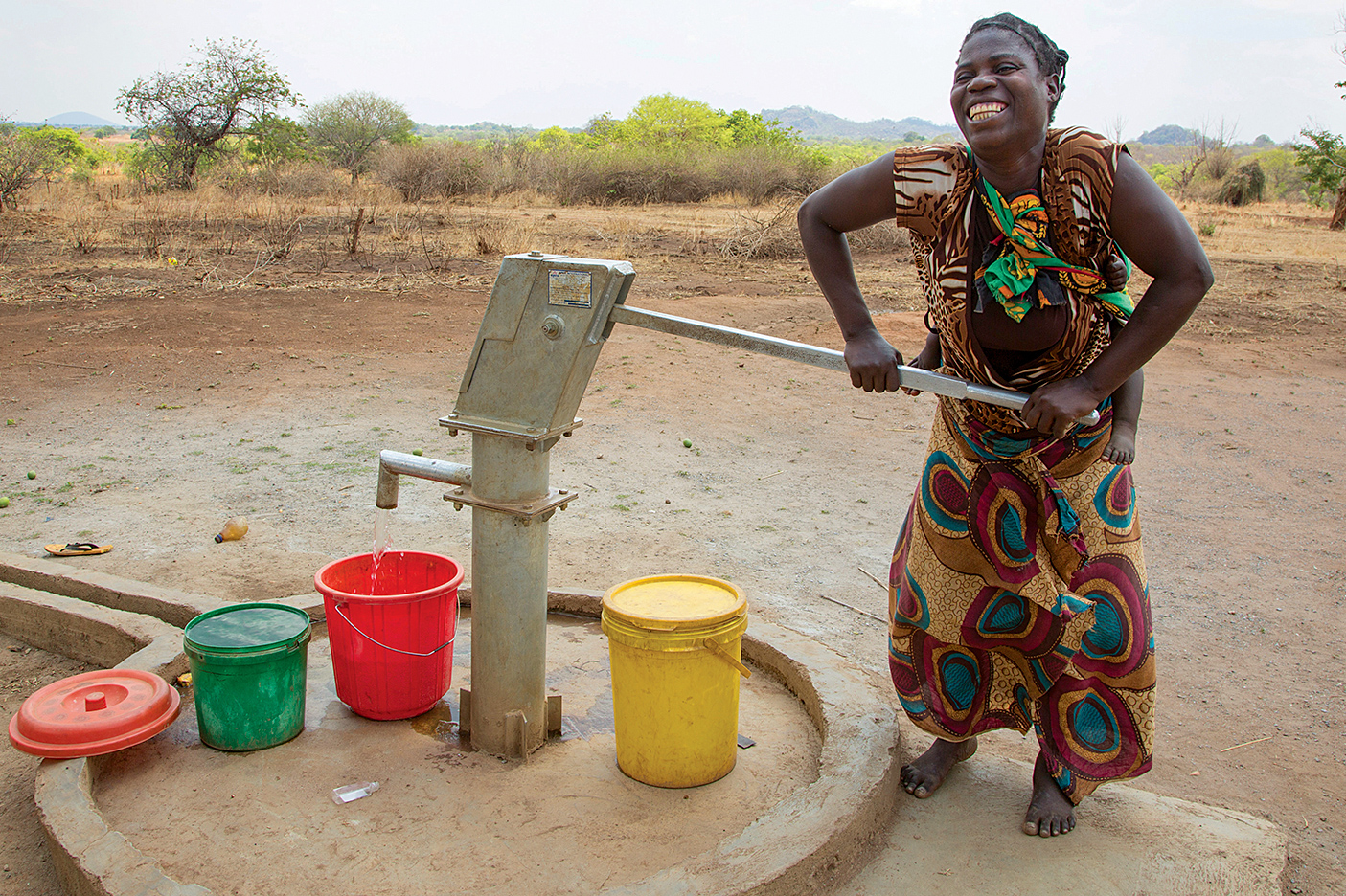 Woman pumping water in Zambian village