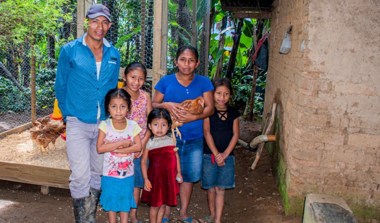 A family in Guatemala stands with their chickens