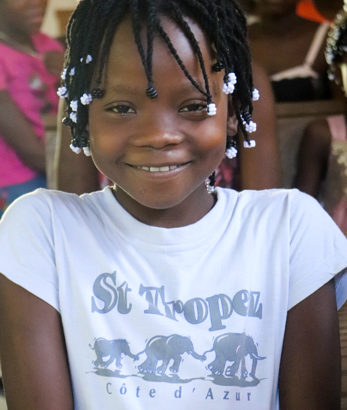 A child smiles, part of Thriving Kids in Haiti