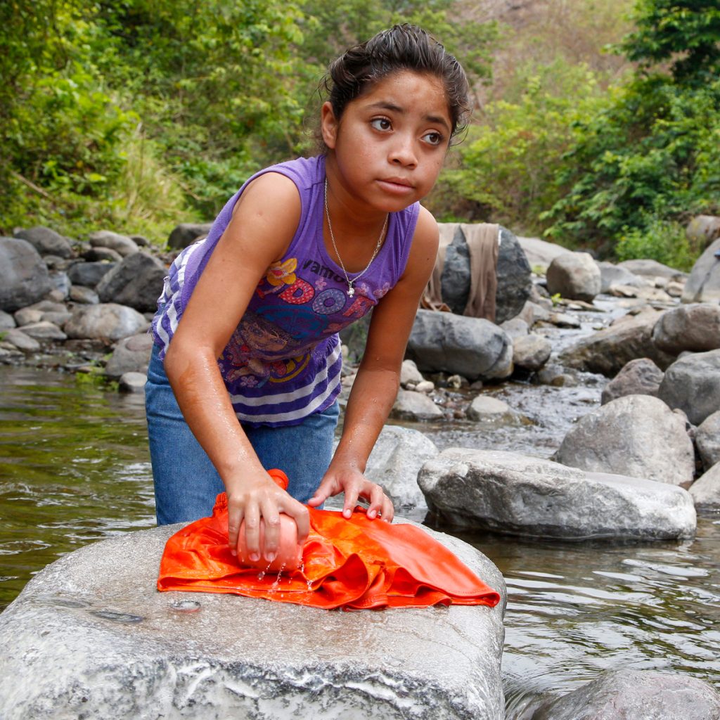 Guatemalan girl washing clothes in the river