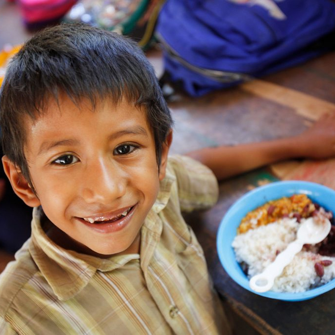 A child eating smiles at the camera