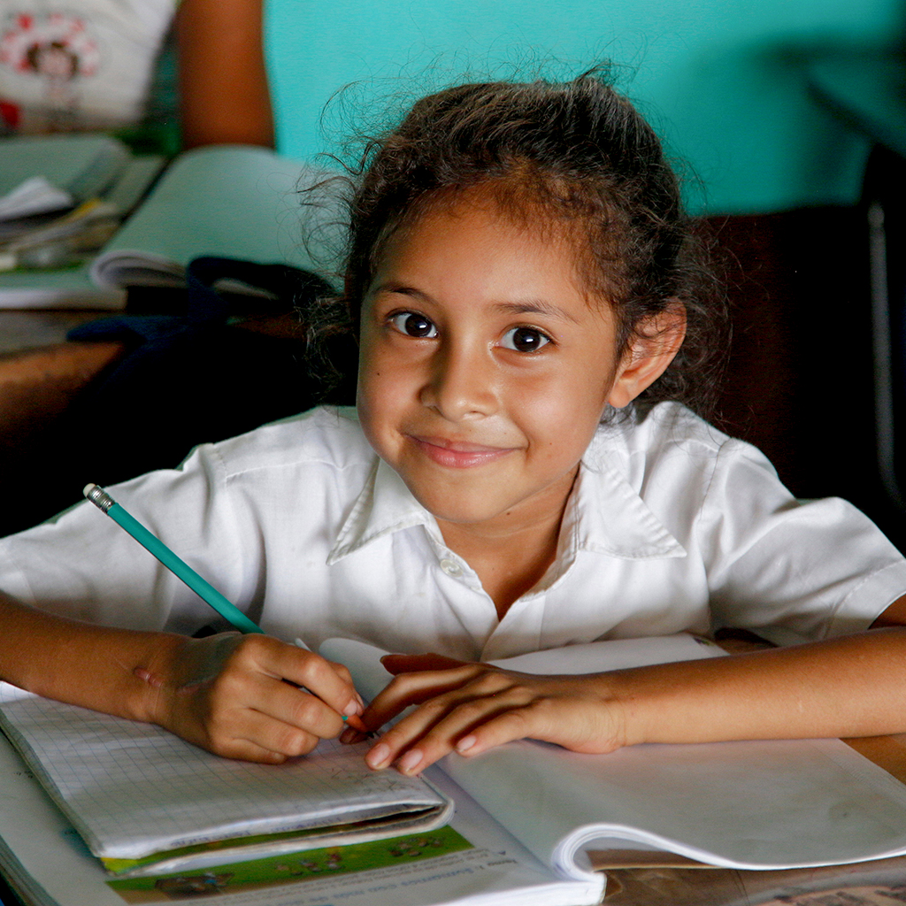 Girl in class, smiling to the camera