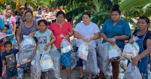 Community in El Cordoncillo, El Salvador receiving packages of food from the Friendly Hand Foundation