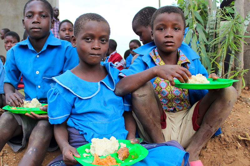 Group of Malawian children receiving lunch