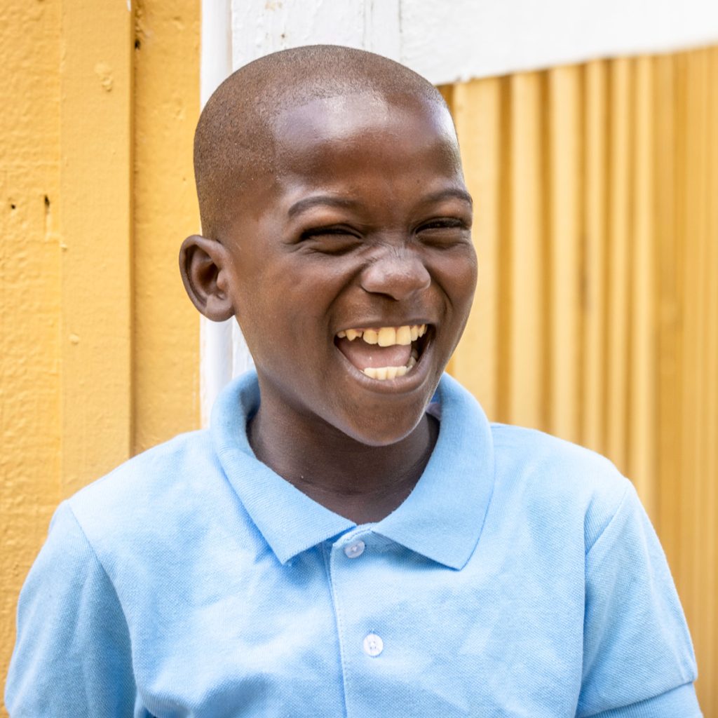 Johnathan, a beneficiary of the Thriving Kids Initiative in the Bateys of the Dominican Republic, laughing joyfully.