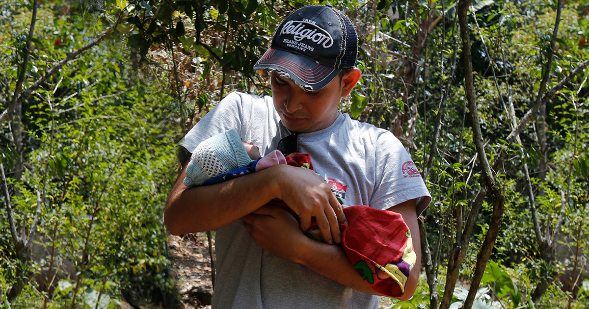 A rescuer cradles baby Romelia in the Guatemalan jungle.