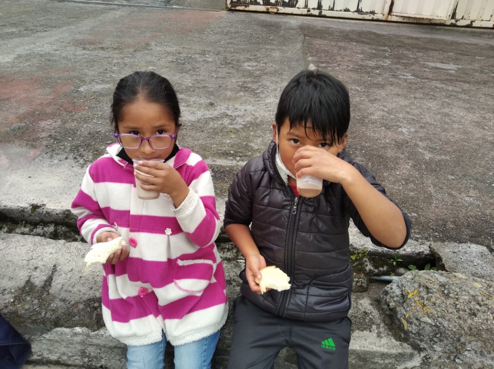 Two children—Diego and Jaqueline—sit side by side drinking.