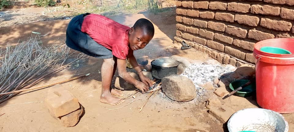 Tamala outside her home in rural Malawi.
