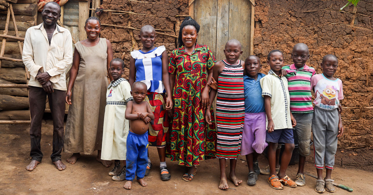 A family gathers in front of a mud-brick and wooden home on the outskirts of Kyakitanga, a rural village in Uganda.