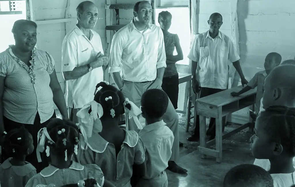 Early Cross International team members visit a classroom, interacting with children during the organization’s early years of ministry.
